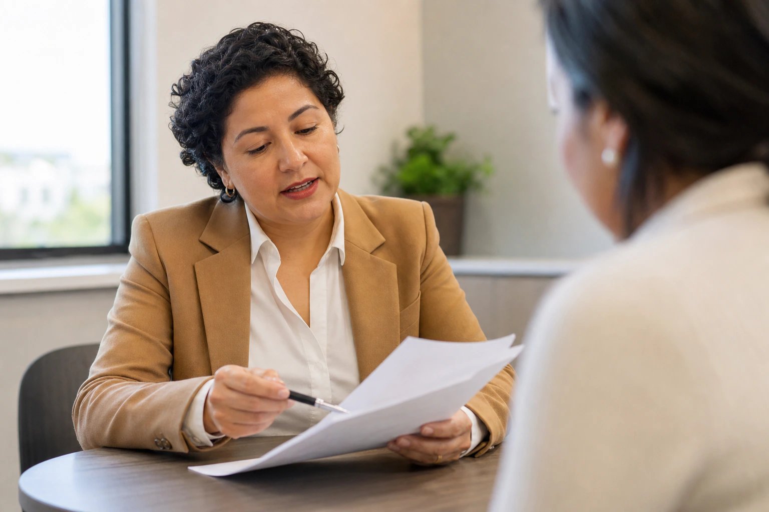 Asesora de seguros revisando con su cliente la gestión de riesgos laborales de la empresa